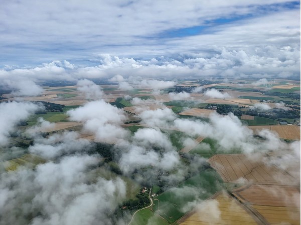 Vue aérienne depuis un ULM au-dessus du Pays de Caux en Seine-Maritime, champs agricoles et nuages lors d’un baptême de l’air près de Dieppe